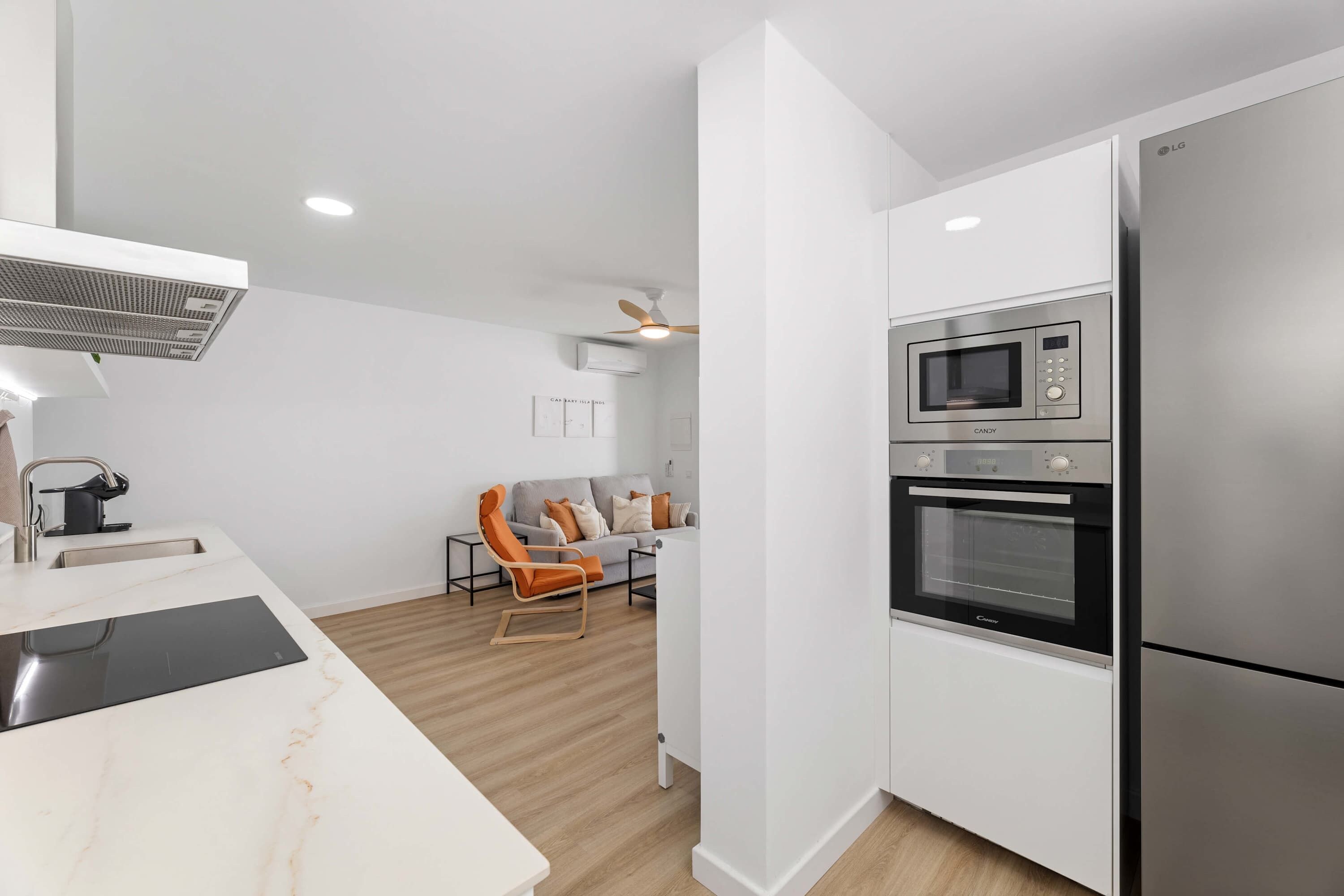 A modern kitchen with a built-in microwave, oven, and refrigerator.