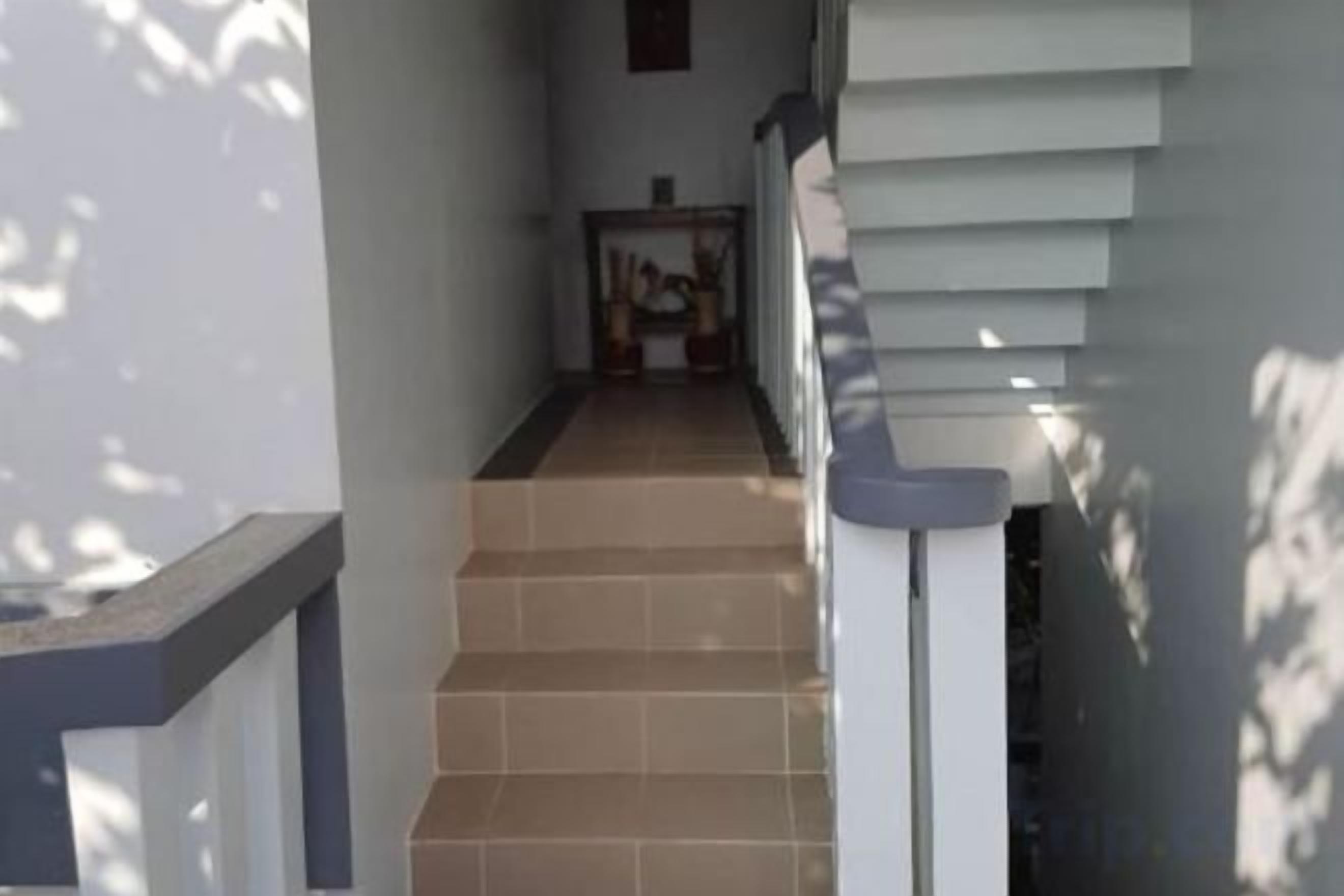 Una escalera que lleva a una plataforma con barandilla a la derecha.