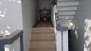 Una escalera que lleva a una plataforma con barandilla a la derecha.