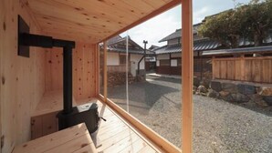A wooden interior with a large sliding glass door leading to a courtyard.