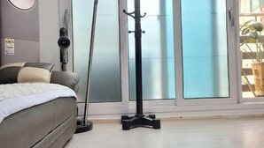 A bedroom with a bed, a standing lamp, and a window with frosted glass. - jeni's house (Seoul)