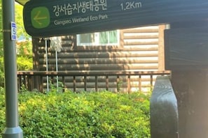 A wooden cabin with a sign indicating Gangseo Wetland Eco Park 1.2 km ahead. - jeni's house (Seoul)