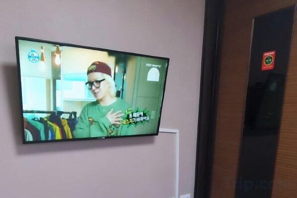A television mounted on a wall displaying a person. - jeni's house (Seoul)