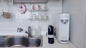 A modern kitchen with a stainless steel sink, a coffee machine, and a water dispenser. - jeni's house (Seoul)