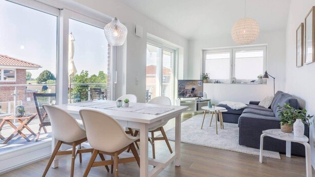 Un apartamento moderno con comedor, sala de estar y balcón.