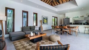 A modern living room with a sofa, coffee table, and dining area.