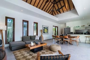 A spacious living area with a sofa, coffee table, and dining table. - Villa Leaf Sanur by BaliSuperHost (Bali)