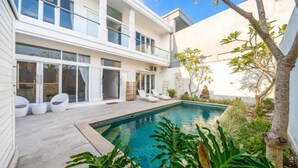 A modern two-story house with a swimming pool, outdoor seating, and a garden. - Villa Casa Antonio (Bali)