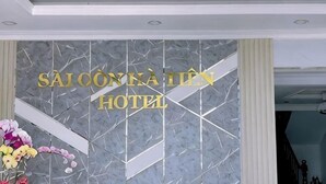 Ein Empfangsbereich mit Marmorwand und einem Schild, auf dem 'SAI CONKATIN HOTEL' steht.