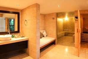 Une salle de bain moderne avec un grand miroir, un lavabo, une douche et un banc en bois.