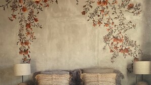 A bedroom with a large bed, two bedside lamps, a hanging light fixture, and floral wall art. - Charming bed & breakfast in Limoux, all roms with private bathroom. (Limoux)