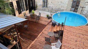 A courtyard with a wooden deck, outdoor seating, and a swimming pool. - Charming bed & breakfast in Limoux, all roms with private bathroom. (Limoux)