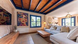 A modern living room with a sofa, coffee table, and artwork on the walls. - Villa Lucentum (Alicante)