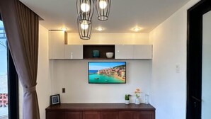 Une chambre moderne équipée d’un téléviseur à écran plat, de meubles en bois et d’un banc.