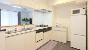 Une cuisine moderne avec des meubles blancs, un four à micro-ondes, un évier et un lave-vaisselle.