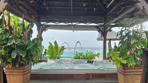 A covered outdoor area with hot tubs and potted plants, overlooking a body of water. - Sipadan Mabul Resort Semporna (Semporna)