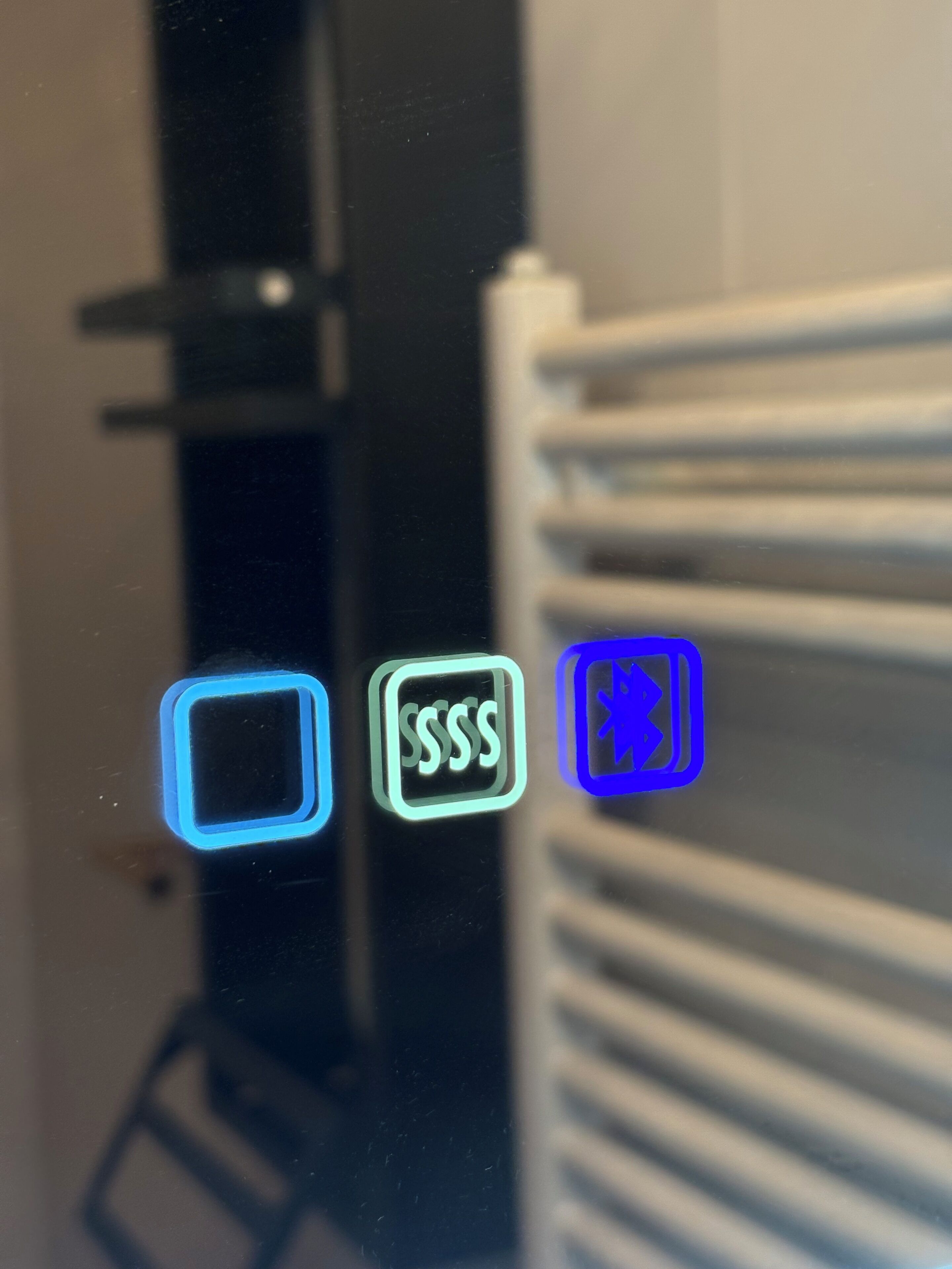 A close-up of a window with three illuminated icons: a square, a square with 'SSSS', and a square with a star.