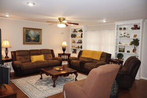 A living room with two sofas, a coffee table, and a bookshelf.
