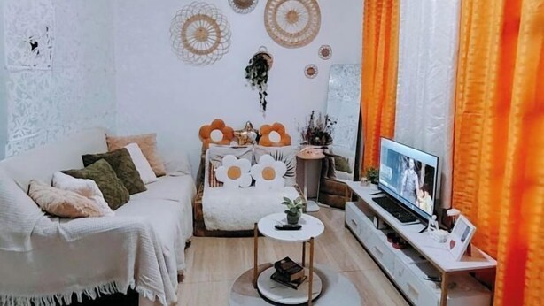 A living room with a sofa, a coffee table, a TV, and orange curtains. - Home in Pagadian City near airport (Pagadian)