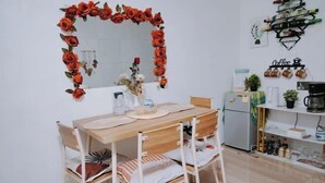A dining area with a wooden table and chairs, a mirror with a floral decoration, and a coffee shelf. - Home in Pagadian City near airport (Pagadian)