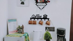 A coffee station with a coffee mug rack, a coffee maker, and a kettle on a table. - Home in Pagadian City near airport (Pagadian)
