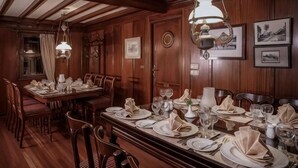 A formal dining room with wooden paneling, a long table set for a meal, and wall-mounted artwork. - Dahabeya Farouz El Nil 3 (Al Bairat)