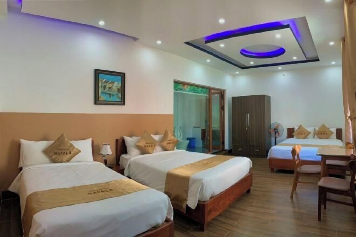 Una habitació d'hotel amb dos llits, una taula de treball i un armari.