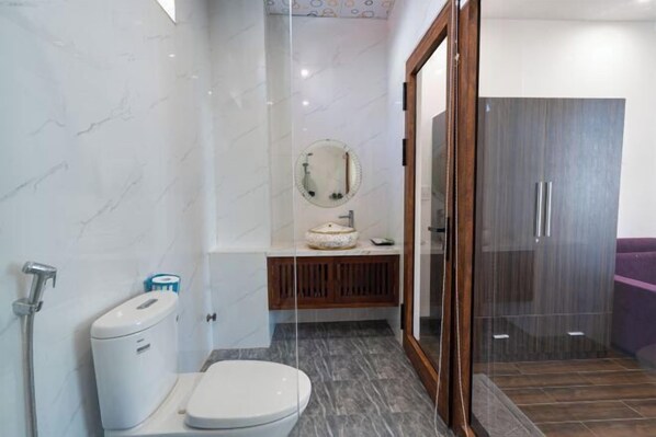 A modern bathroom with a toilet, sink, and mirror.