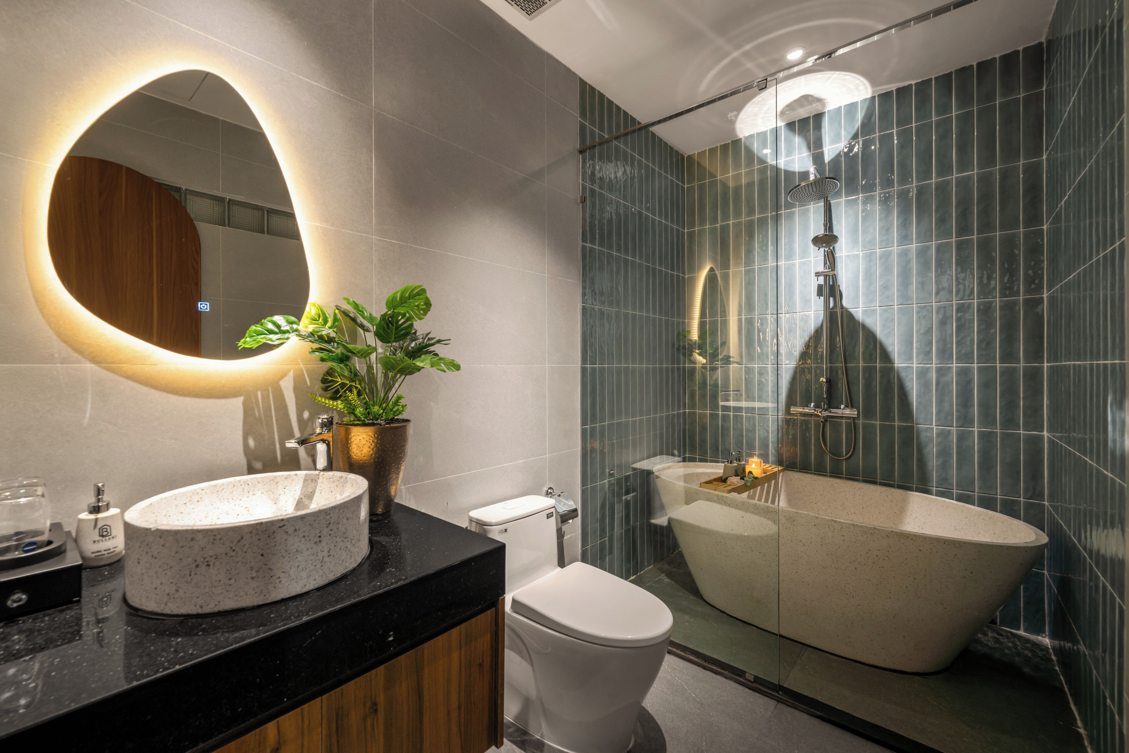 A modern bathroom with a freestanding bathtub, a round mirror, and a potted plant.