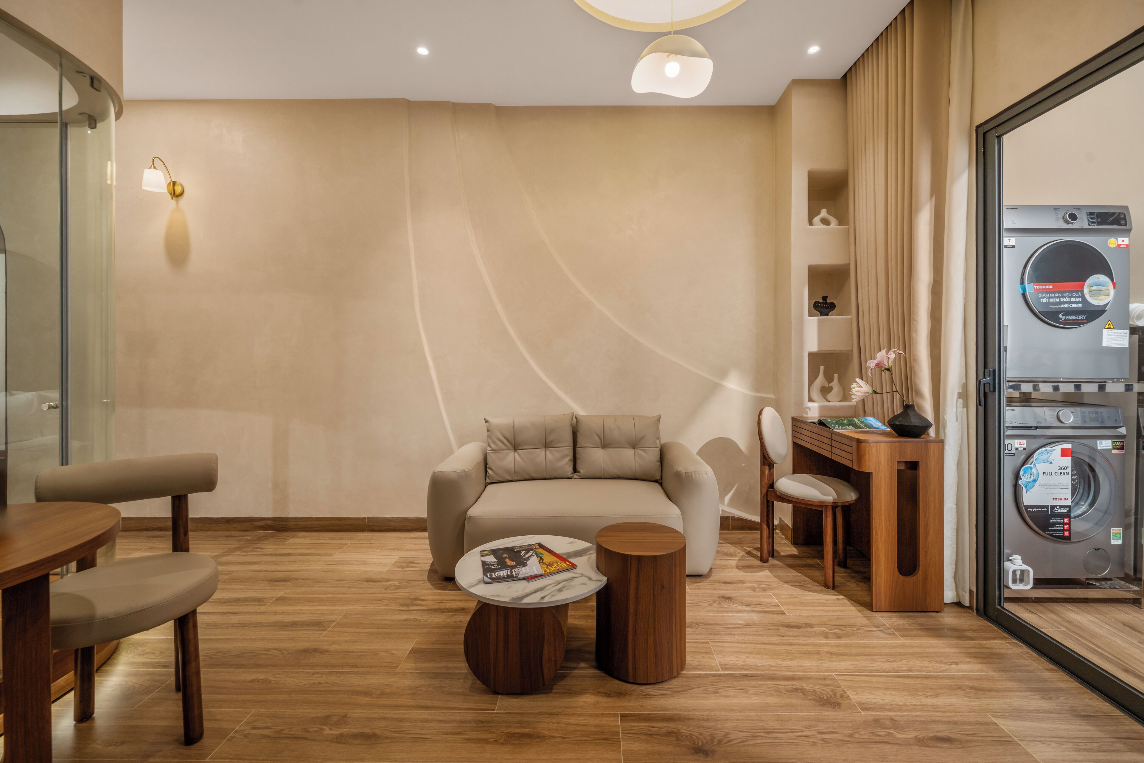 Uma sala de estar moderna com sofá, mesa de centro e máquina de lavar roupa.