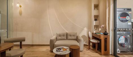 Uma sala de estar moderna com sofá, mesa de centro e máquina de lavar roupa.