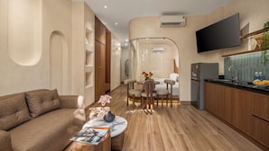 Un salon moderne avec un canapé, une table basse et un téléviseur fixé au mur.