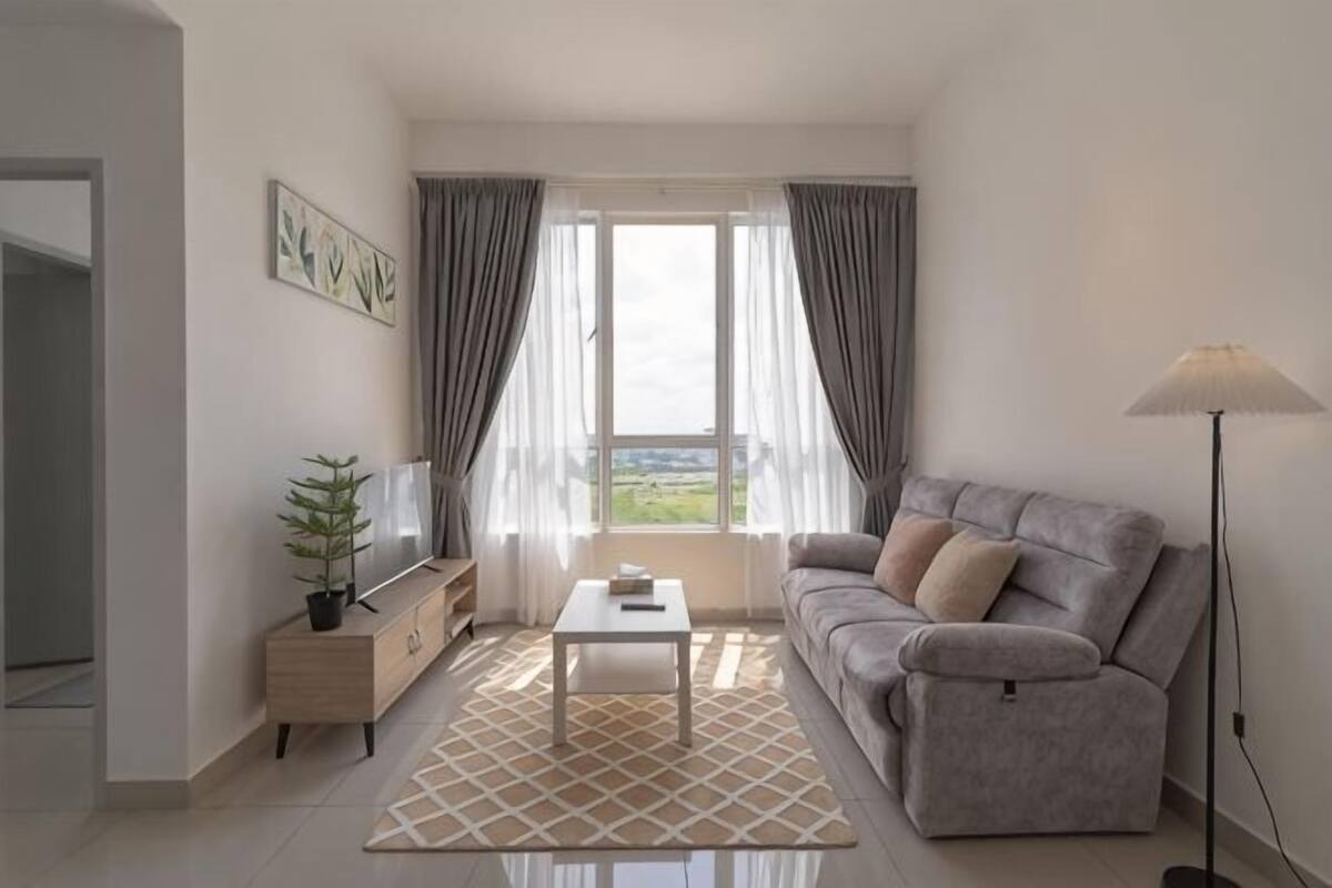 Uma sala de estar com sofá, mesa de centro e abajur.
