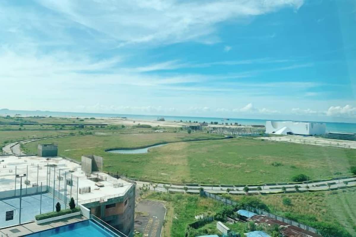 Uma área de piscina no terraço, com vista para a paisagem ao redor e um edifício grande ao longe.