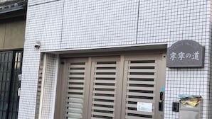 A building with a tiled facade and a sign indicating it is a guest house. - Nenenomichi (Kyoto)