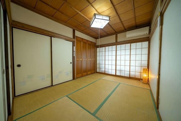 A traditional Japanese room with tatami flooring, sliding doors, and a shoji screen. - Tolai ryokan 1gokan (Atami)