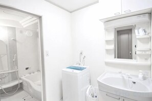 Un baño con bañera, lavamanos y zona de ducha.