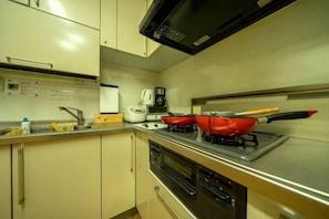A kitchen with a stove, microwave, and a coffee maker.