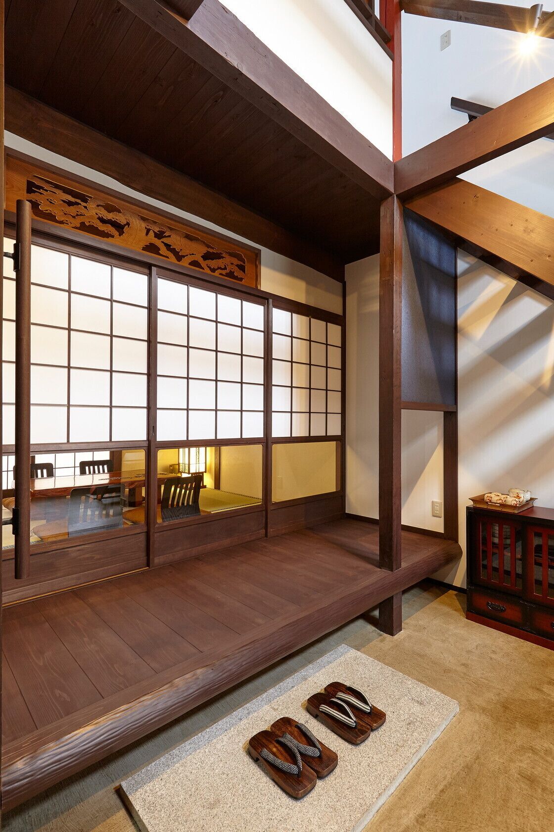 Ein traditioneller japanischer Raum mit Tatami-Bodenbelag, einer verschiebbaren Shoji-Trennwand und einer niedrigen Holzbank.