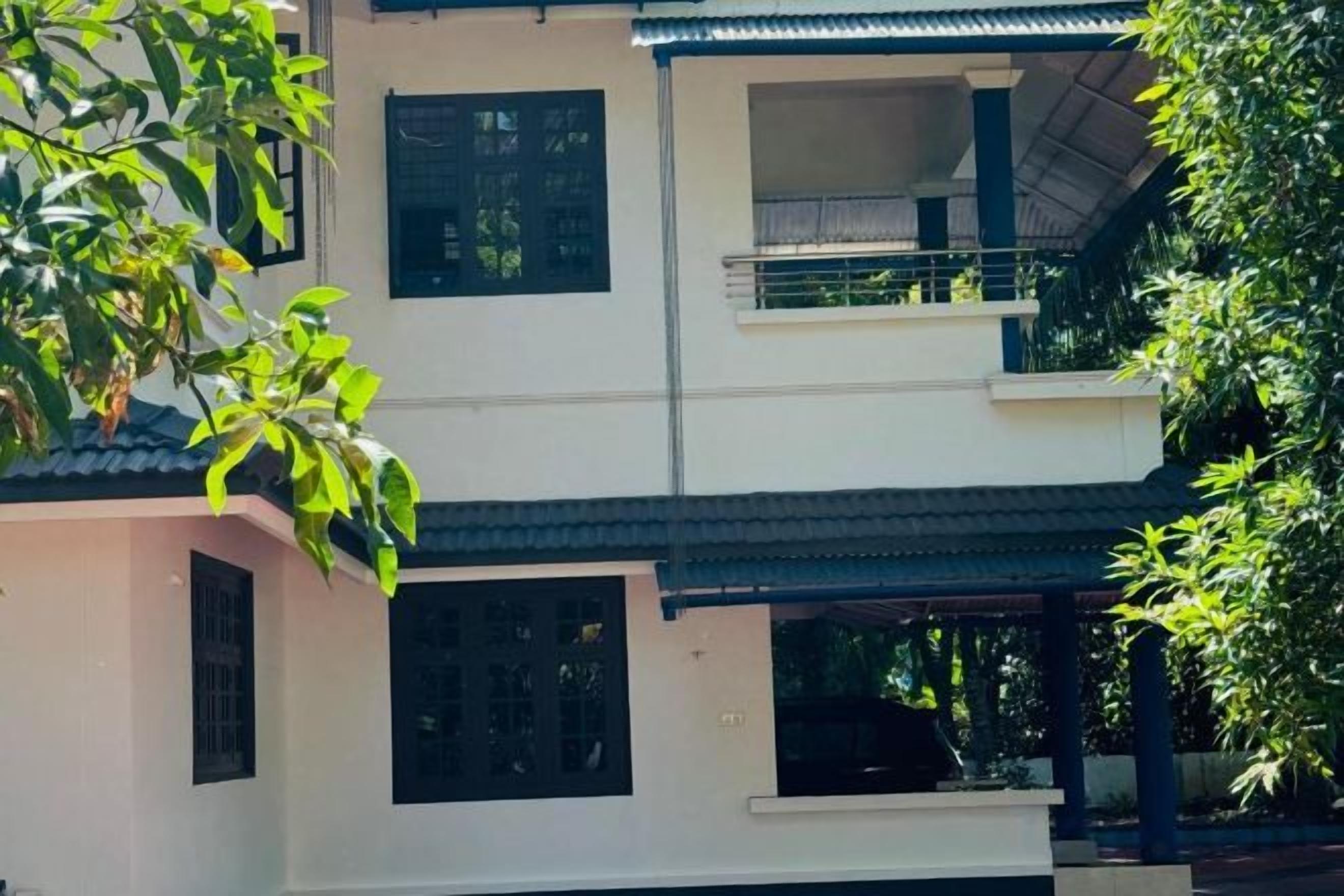 Un edificio de varios pisos con balcones y un espacio exterior cubierto.
