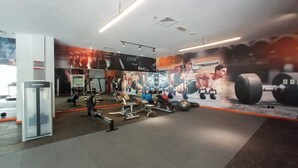 A gym with exercise equipment, a mirror, and motivational posters on the walls. - JVC 1 bed for 3 People With Swimming Pool (Dubai)