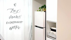 A kitchen with a refrigerator, a plant on top, and a wall with a motivational quote. - Hongik University Station 8min/Bedroom 3/Bed 4/Parking Available [Vanilla House] (Seoul)
