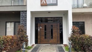 A modern building entrance with a sign reading "A 1" and a wooden door. - Apartments in Tashkent City 2 (Tashkent)