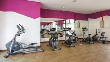 A gym with exercise equipment and a large mirror.