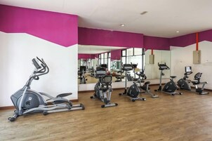 Un gimnasio con equipo de ejercicio y un espejo grande.