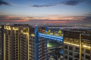 Un grattacielo con numerosi piani, un ponte e uno skyline urbano sullo sfondo.