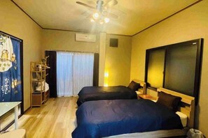A hotel room with two beds, a ceiling fan, a desk, a chair, and a wardrobe. - Remembrance (Osaka)