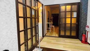 A traditional Japanese room with sliding doors, a wooden floor, and a visible fire extinguisher. - Remembrance (Osaka)