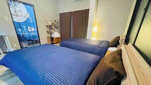A room with a bed, a wardrobe, a shelf with items, and a poster on the wall. - Remembrance (Osaka)