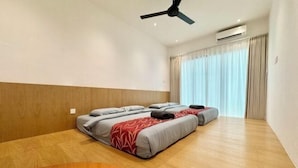 A hotel room with two beds, a ceiling fan, an air conditioning unit, and a large window with curtains. - Luxury 5BR Home w/ Private Pool, 18Pax, Netflix (Langkawi)